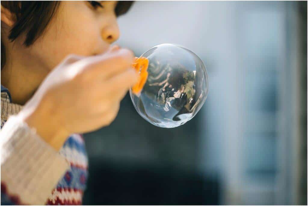 child blowing bubble