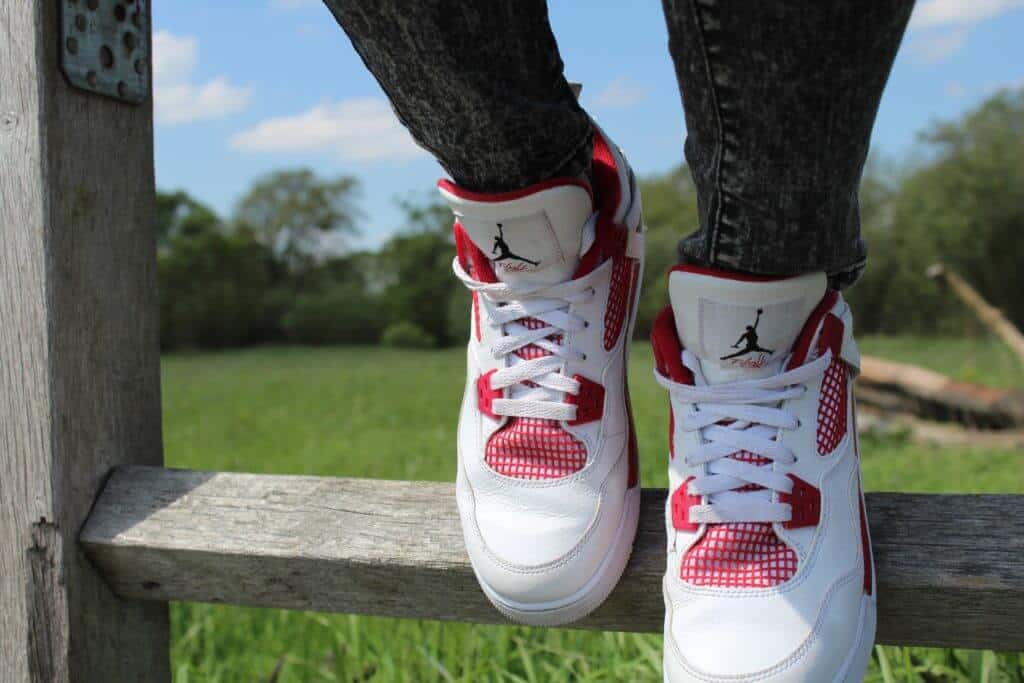 White and red sneakers on wooden fence