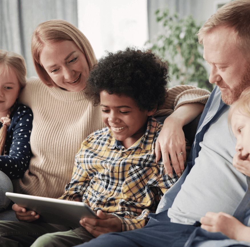 Multi-racial family looking at an iPad together.